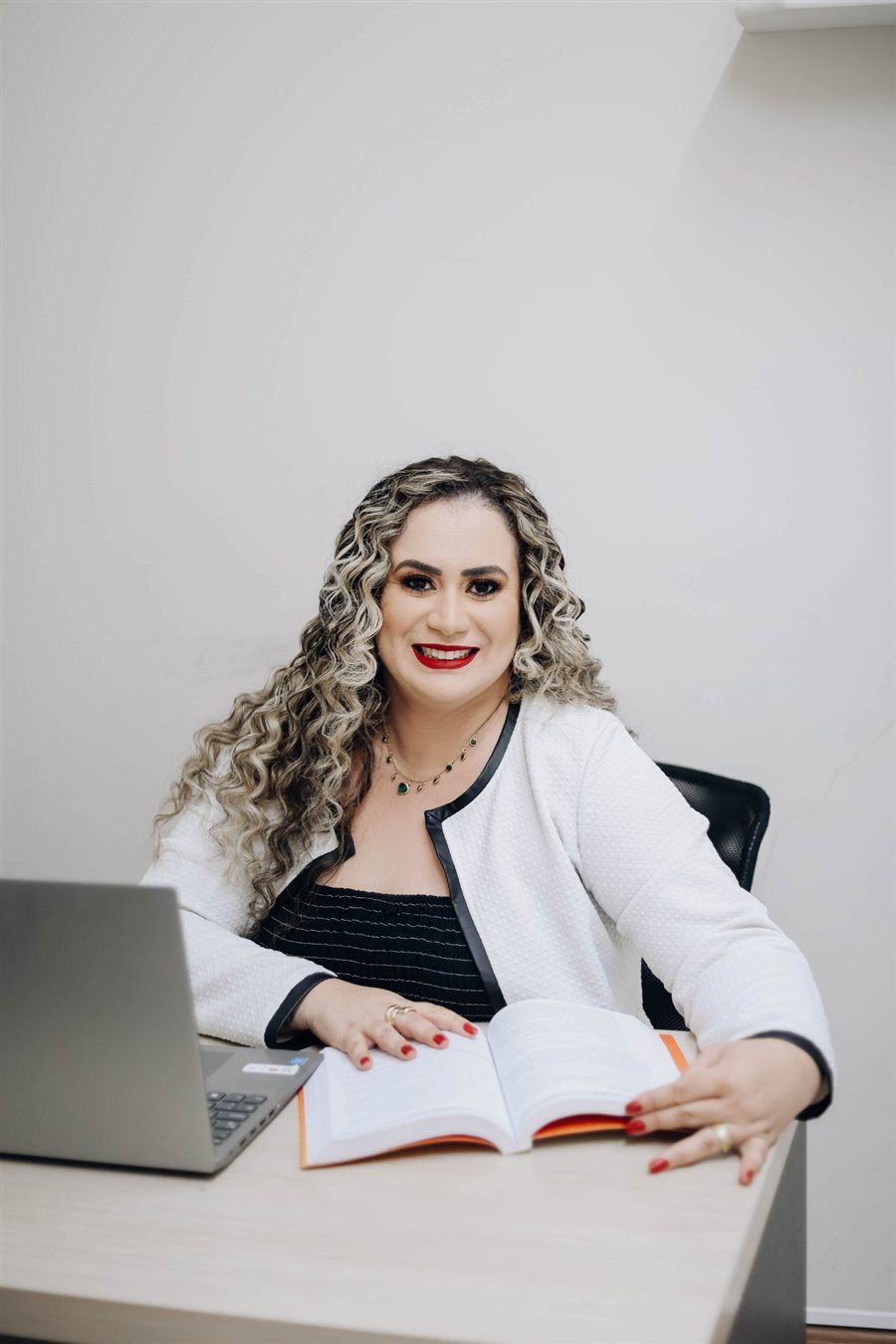 Jéssica Lima, advogada, sorrindo à mesa de trabalho